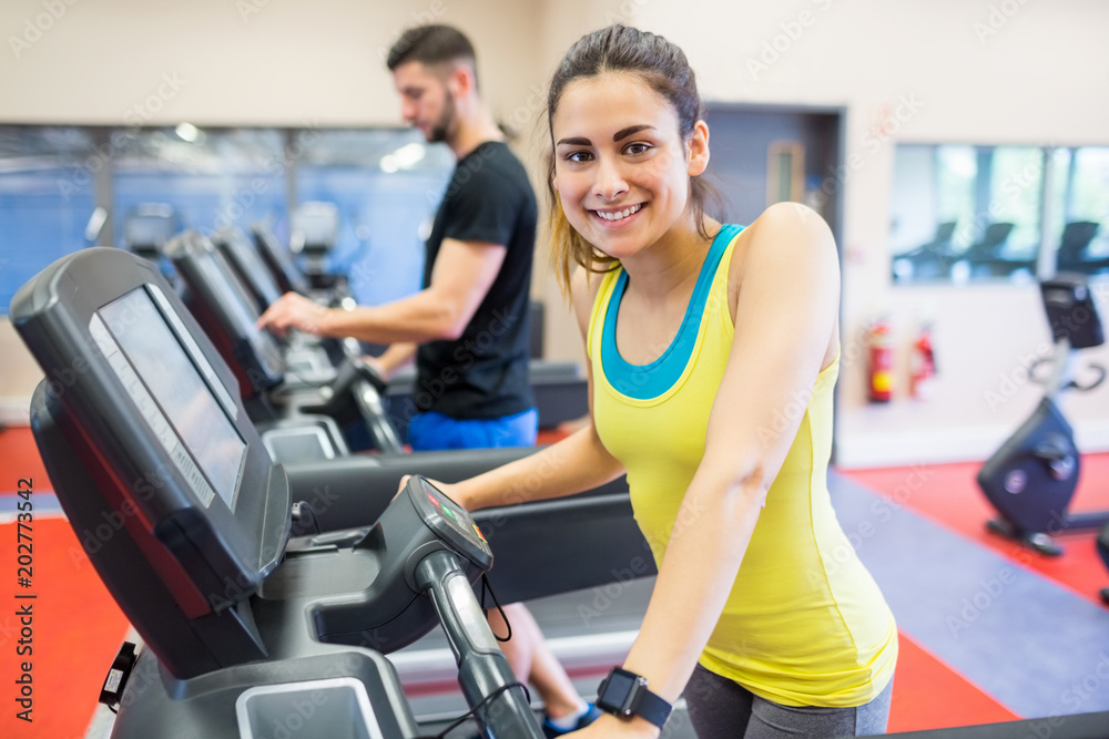 Fototapeta premium Couple using treadmills together