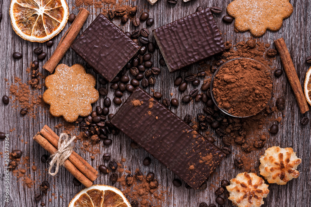 Confectionery products- chocolate wafers, cookies, coconut biscuits on a wooden table, top view. Confectionery products- chocolate wafers, cookies, coconut biscuits on a wooden table, top view.