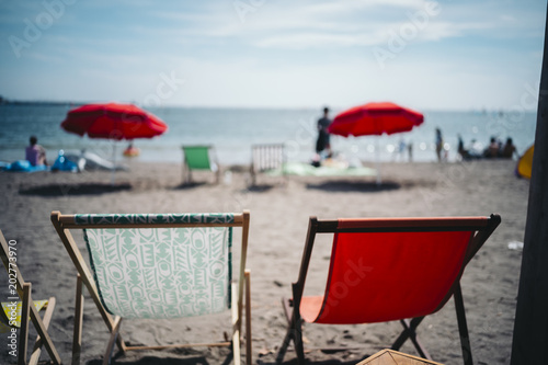 There are two beach chairs, red and green photo