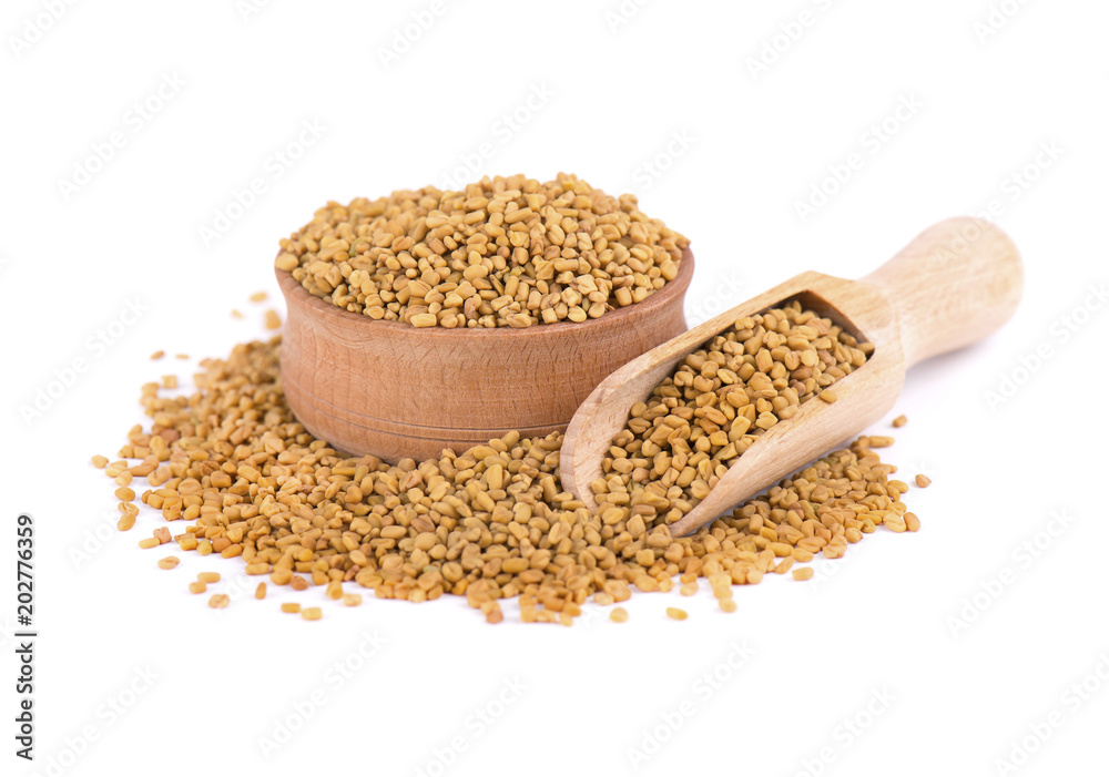Fenugreek seeds in wooden spoon, isolated on white background Fenugreek seeds in wooden spoon, isolated on white background
