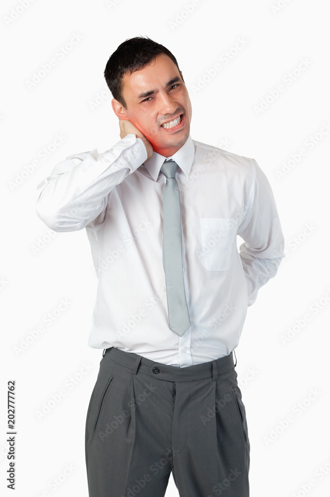 Portrait of a young businessman having a back pain against a white background Portrait of a young businessman having a back pain against a white background