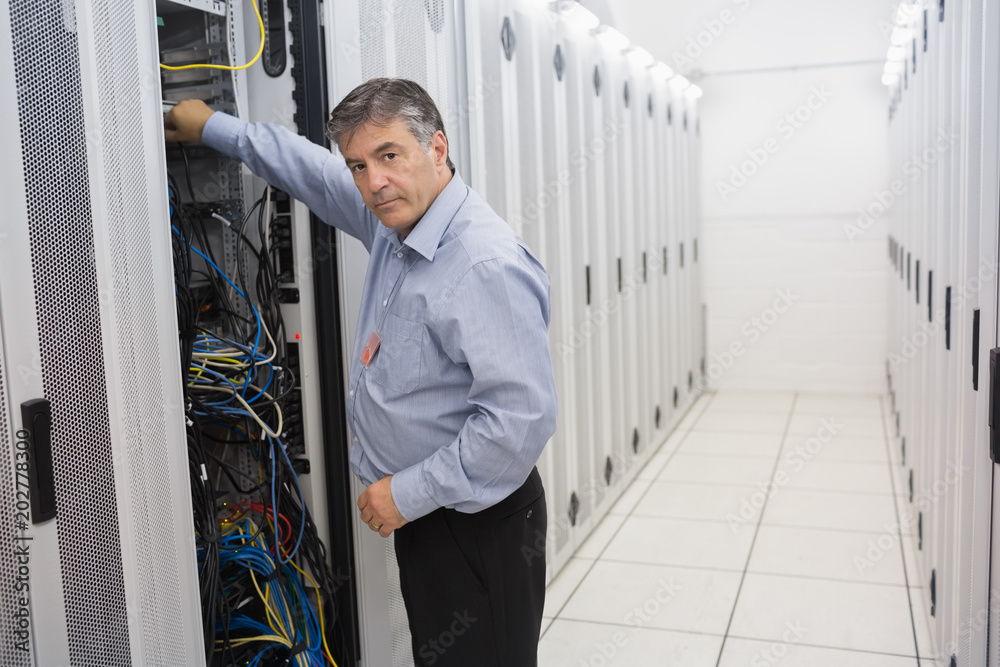 Man fixing wires of servers Man fixing wires of servers