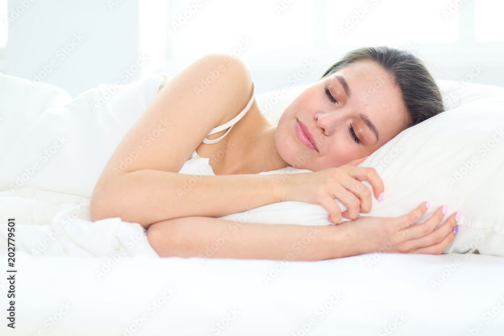 Fototapeta Ładna kobieta siedzi na łóżku w domu