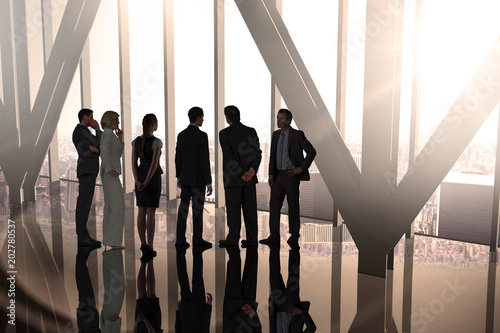 Composite image of business colleagues standing in large room overlooking city