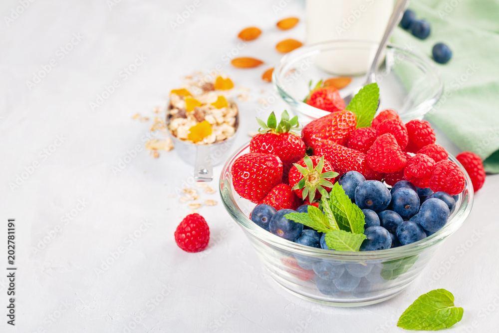 Homemade granola or oatmeal muesli with nuts, dried fruits and fresh berries. Healty diet breakfast, vegeterian food concept