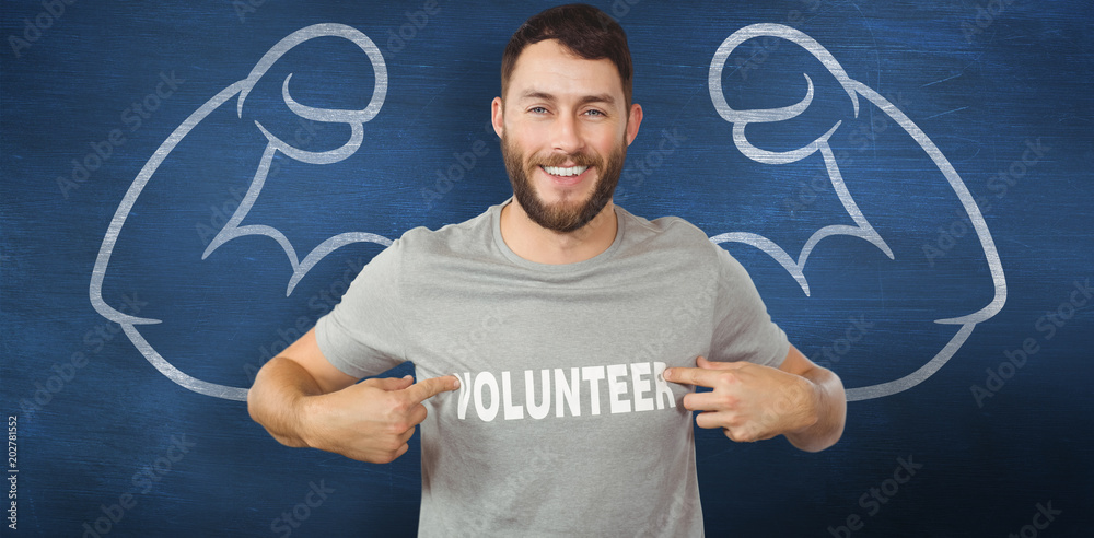 Man showing volunteer text on tshirt  against blue chalkboard