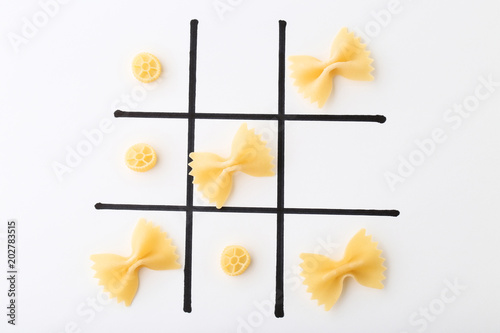 Tic tac toe game by pasta on white background