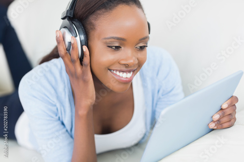 Black woman holding a tablet computer while smiling