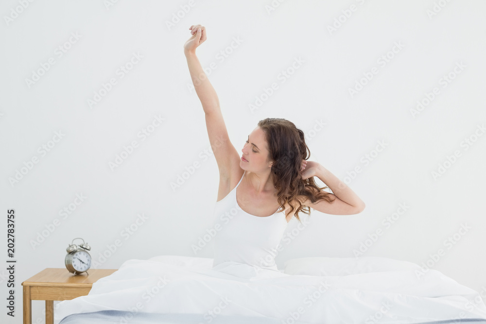 Sleepy woman stretching her arms in bed Sleepy woman stretching her arms in bed