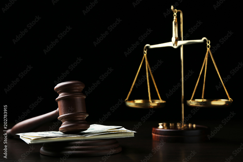 Judge gavel with dollars and scales on wooden table Judge gavel with dollars and scales on wooden table