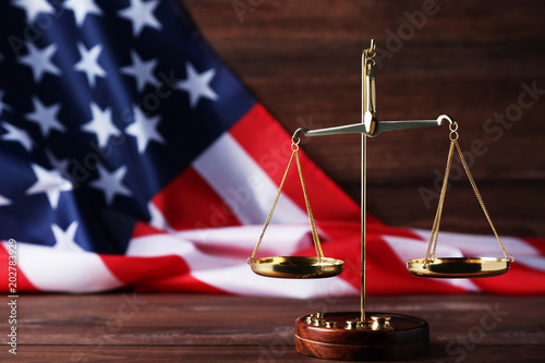Cuadro en lienzo Scales of justice with american flag on brown wooden table