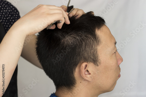 Hairdresser cuts a man, close-up