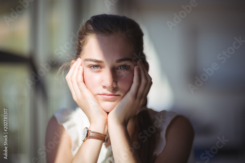 Pretty schoolgirl sitting in classroom