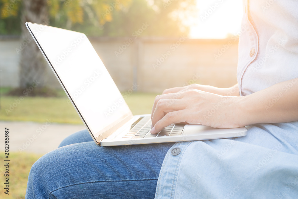 Naklejka premium Business asian woman working laptop for socializing on a background blurred in the garden.