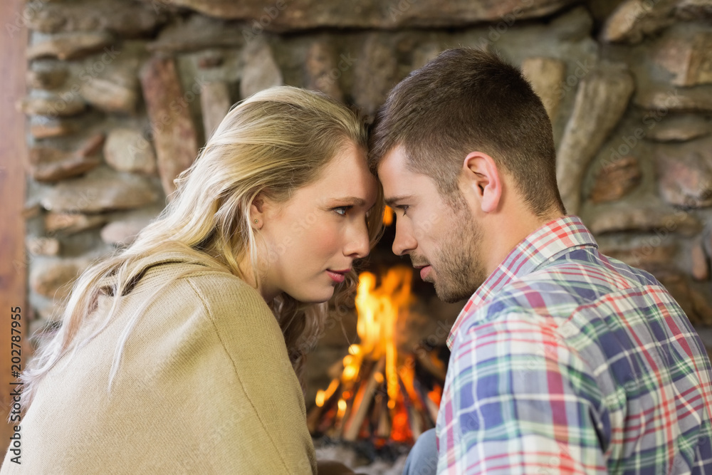 Romantic young couple in front of fireplace