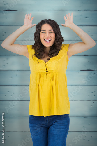 Smiling casual young woman posing against wooden planks