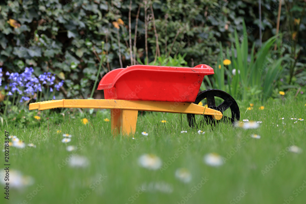 Der kleine Gärtner, Gärtnerin, Kinderschubkarre im Garten Stock Photo