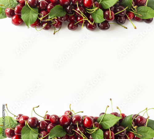 Fresh red cherries  at border of image with copy space for text. Background of cherries. Ripe cherry on a white background. Top view. Cherry fruit.