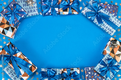 Gift boxes composition on blue background. Flat lay text space.