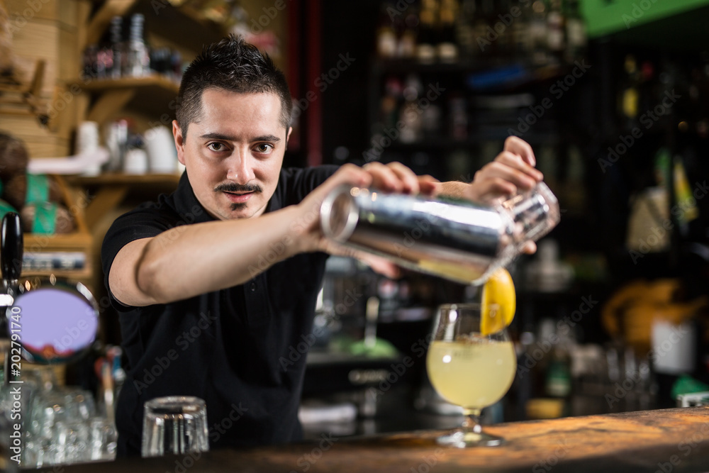 Male barista making lemonade cocktail