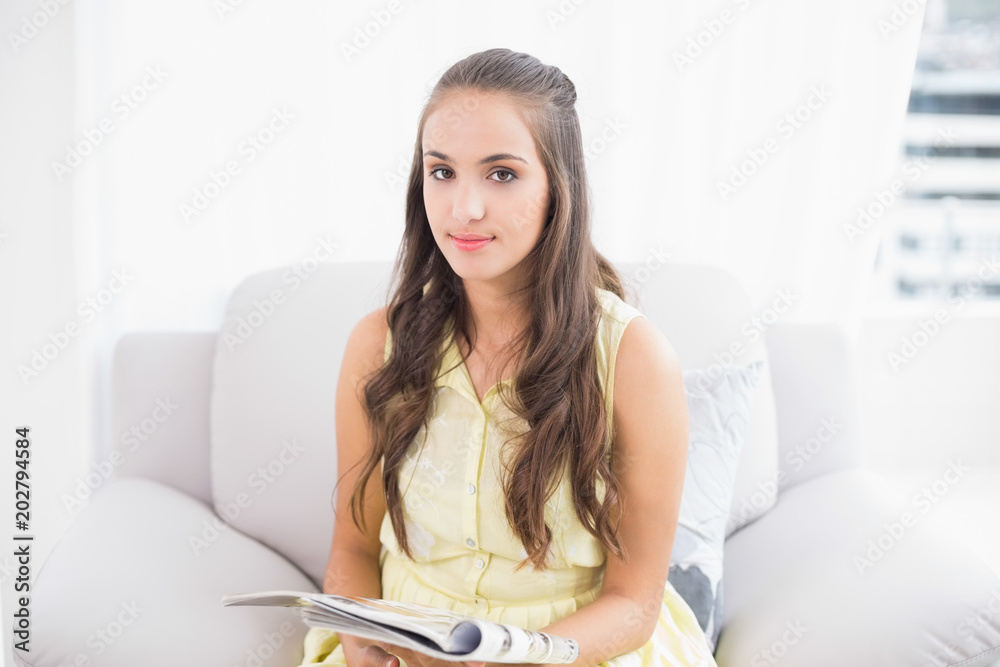 Content young brunette holding magazine Content young brunette holding magazine