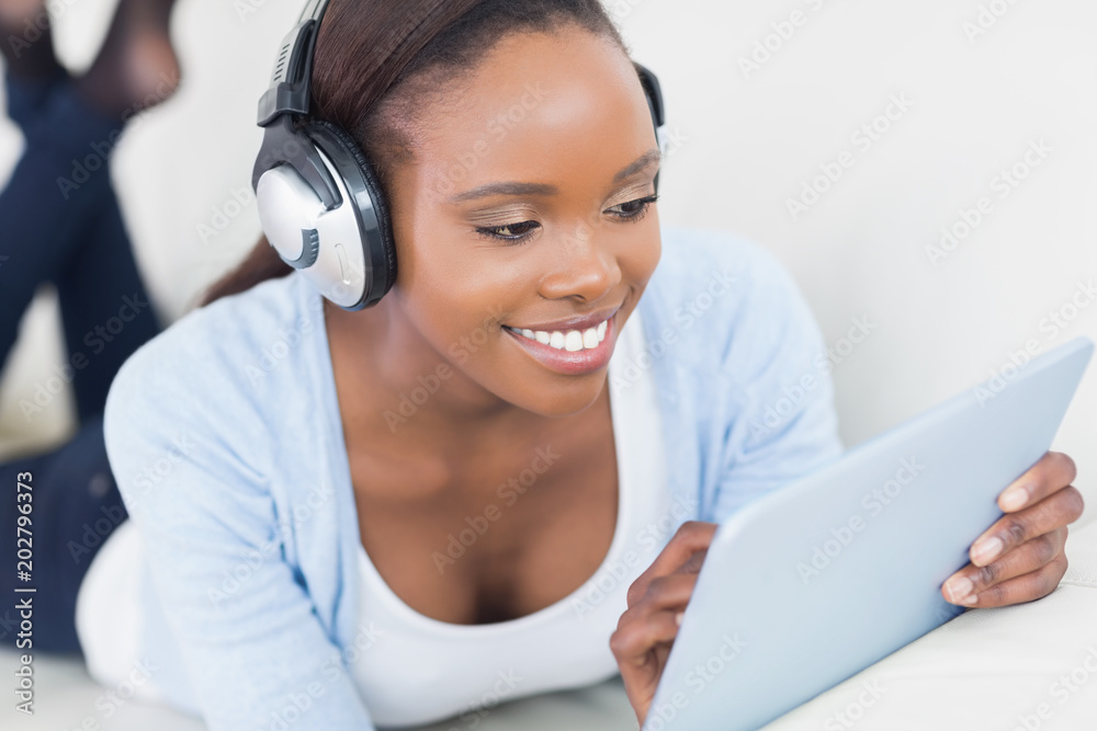 Black woman lying on front using a table computer Black woman lying on front using a table computer