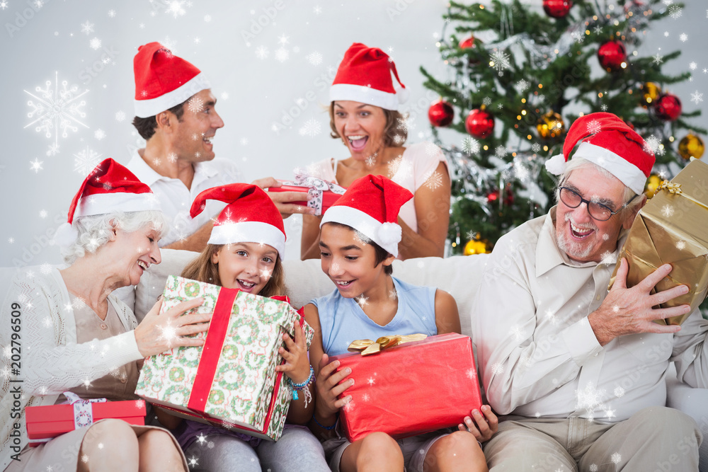 Composite image of Family swapping christmas presents against snow falling Composite image of Family swapping christmas presents against snow falling