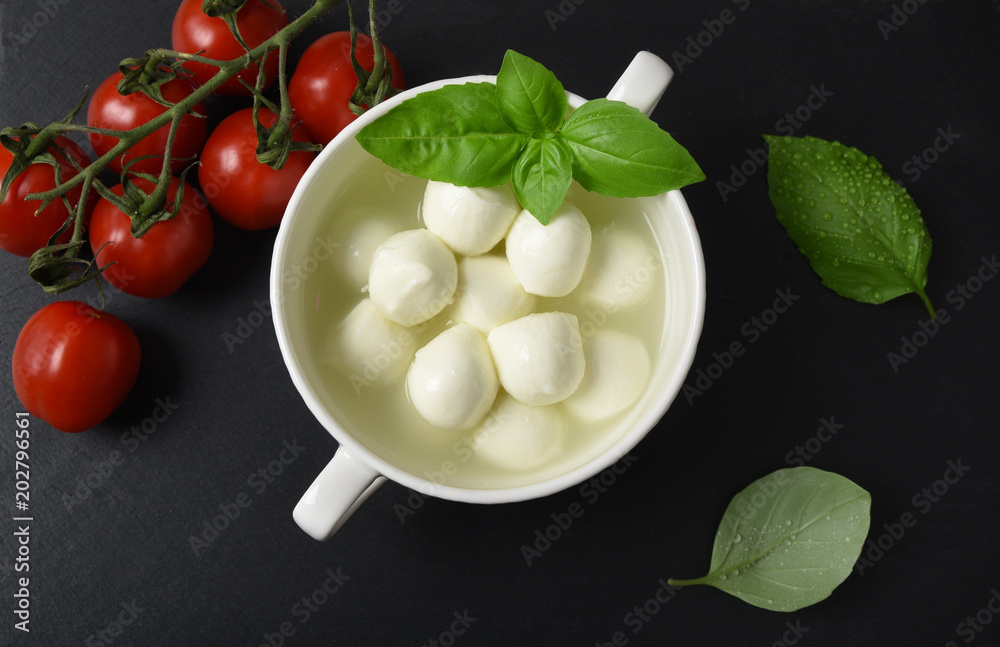 Mozzarella cheese, basil and tomatoes cherry on a gray background italian food, top view