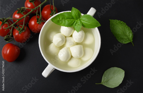 Mozzarella cheese, basil and tomatoes cherry on a gray background italian food, top view
