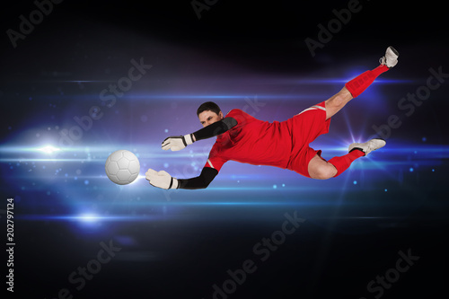 Fit goal keeper jumping up against black background with spark