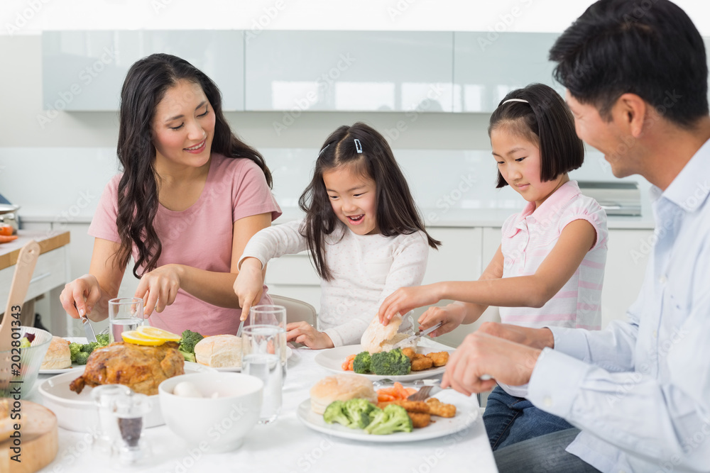 Family of four enjoying healthy meal in kitchen