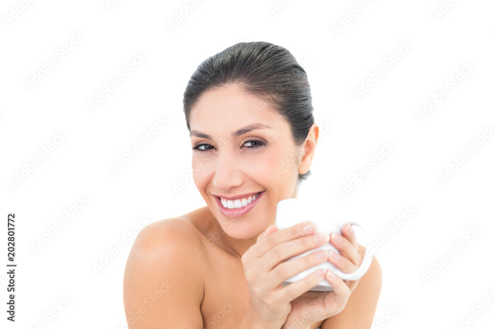 Pretty brunette holding a white mug and smiling at camera Pretty brunette holding a white mug and smiling at camera