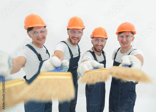 smiling group of builders with a paint brush