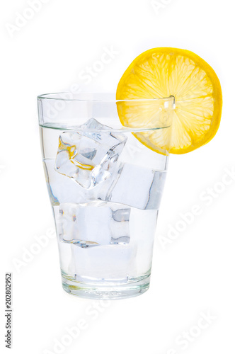 A glass beaker with crystal clear water, lemon and ice cubes. Isolated.