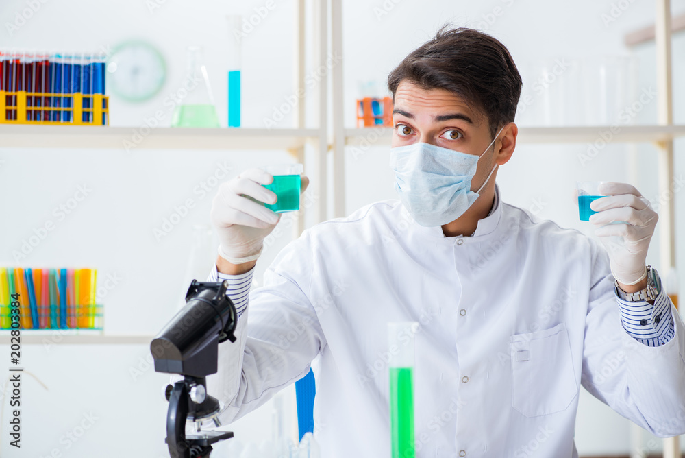 Young chemist student working in lab on chemicals Young chemist student working in lab on chemicals