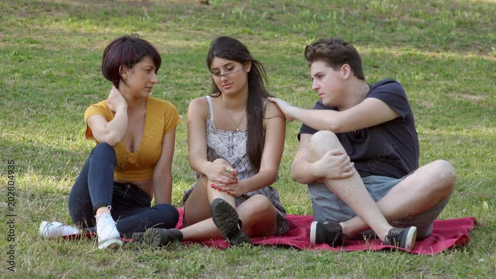 friendship, youth, comfort - three friends sitting on the lawn chat friendship, youth, comfort - three friends sitting on the lawn chat