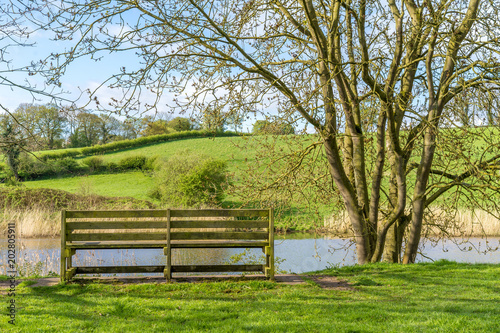 Empty Bench overlooking River Bank of the River Weaver in Cheshire near Northwich UK