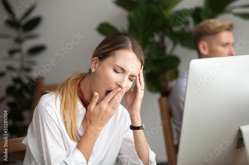 Bored businesswoman yawning at workplace feeling no motivation or lack of sleep tired of boring office routine, exhausted restless employee gaping suffering from chronic fatigue or overwork concept