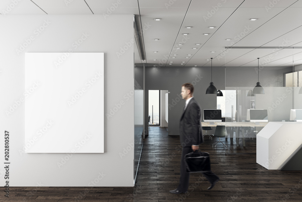 Businessman in modern office with empty wall