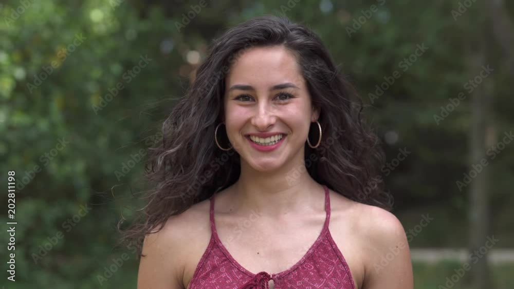 Beautiful attractive Young Woman Smiles Into Camera in the park Beautiful attractive Young Woman Smiles Into Camera in the park