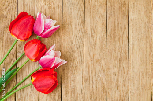 A beautiful bouquet of red tulips on a wooden background