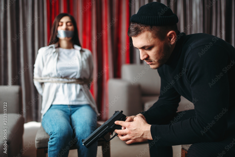 Obraz na plátně Killer sitting with gun against his female victim