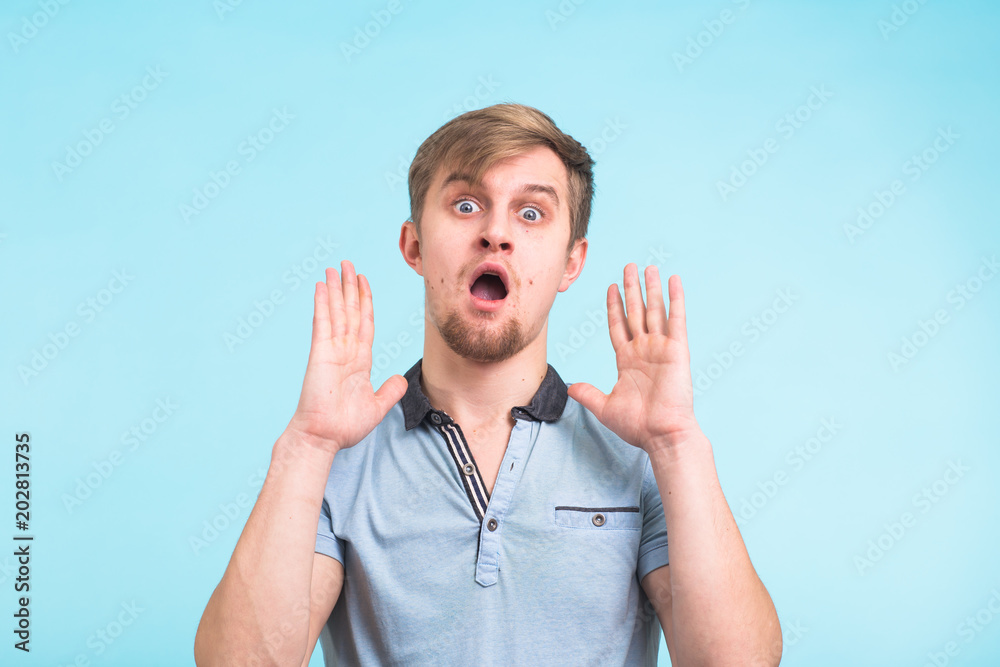 Portrait of young surprised emotional big eyes man with open mouth