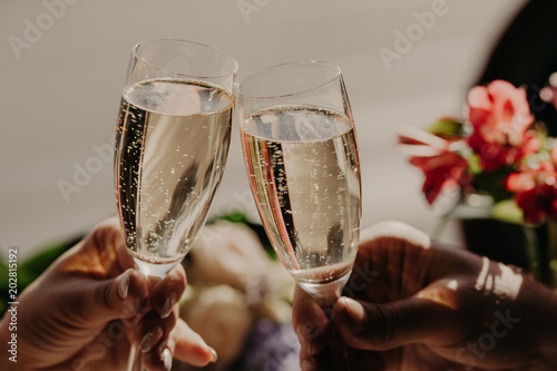 Marriage and wedding concept. Romantic couple in love celebrate their wedding day, clink glasses of sparkling champagne. Newlyweds with acloholic drink photo