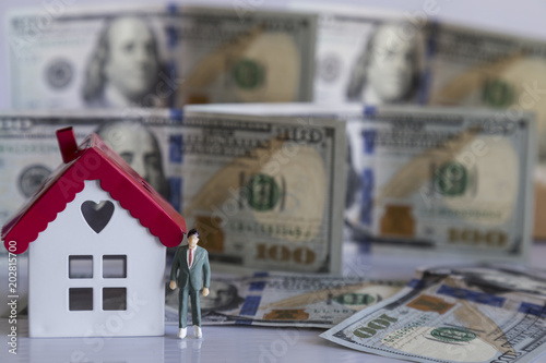 Real estate and mortgage investment. Being an easy way homeowner.Dollars,model businessman and house on the white background.