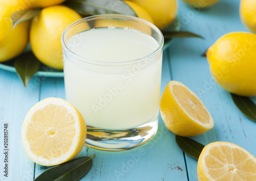 Glass of organic fresh lemon juice and fruits photo