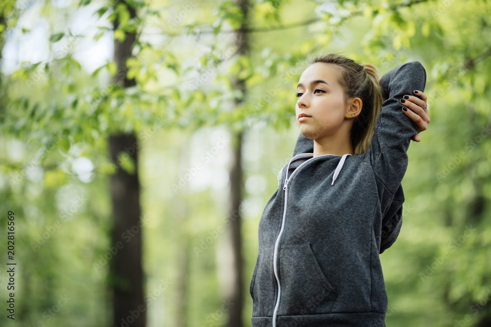 Young female workout at the park. Young woman is warming up and stretching her arms at outdoors on morning. Health care and sport concept. Exercising. Young female workout at the park. Young woman is warming up and stretching her arms at outdoors on morning. Health care and sport concept. Exercising.