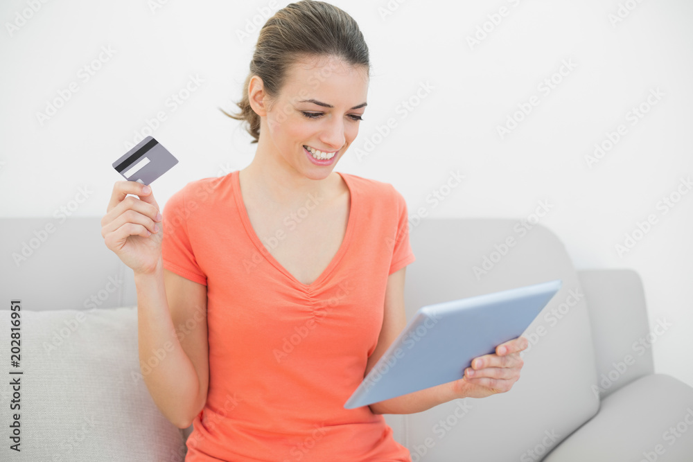 Content lovely woman home shopping with her tablet Content lovely woman home shopping with her tablet