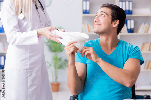 Disabled man in wheel chair visiting woman doctor