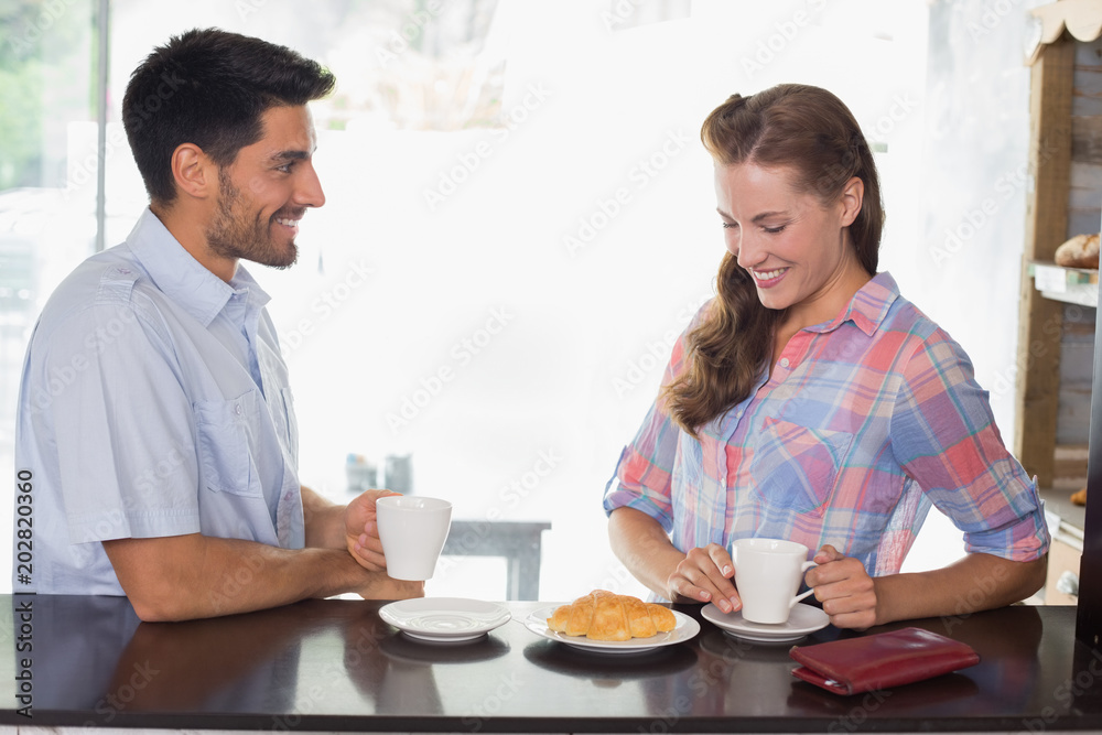 Couple with coffee and croissant at coffee shop